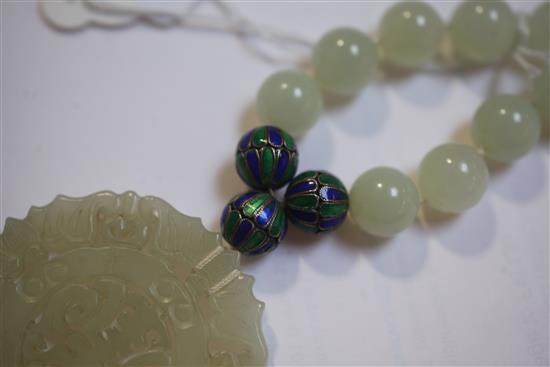A celadon jade and two colour enamel bead necklace with carved jade pendant, 32in.